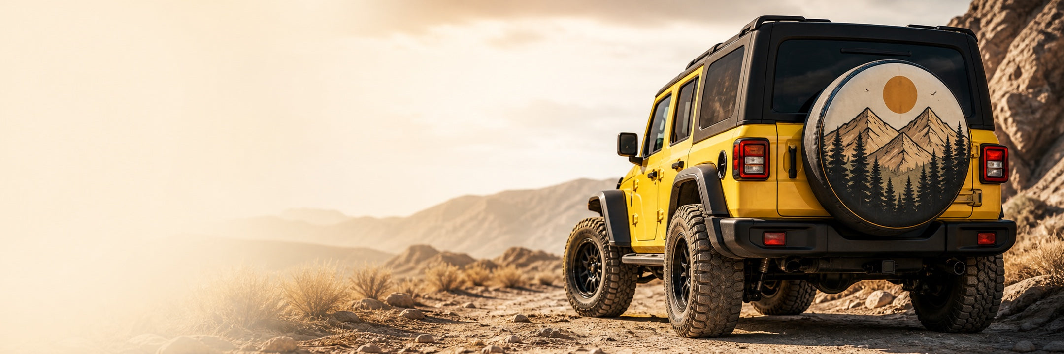 Yellow off-road vehicle featuring a custom mountain-design spare tire cover